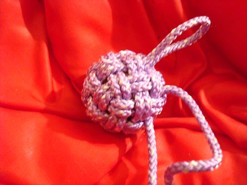 Working a loop of excess cord through the knot.